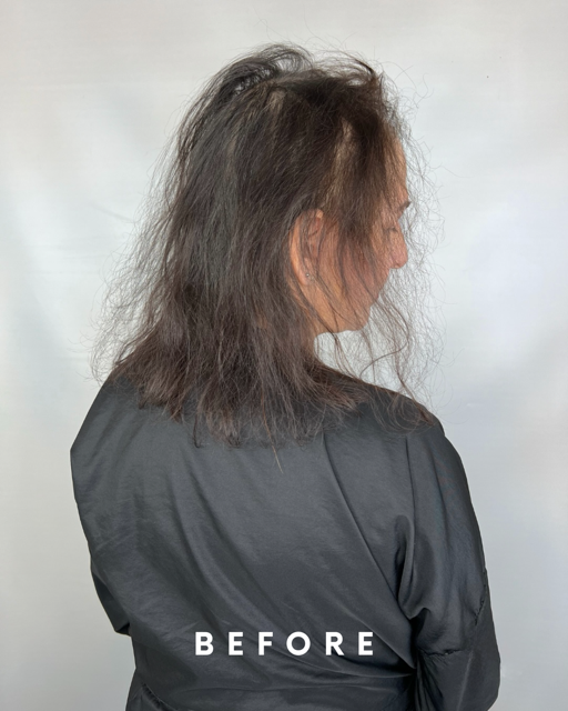 Side view of a woman with messy, shoulder-length hair wearing a dark top, facing right.