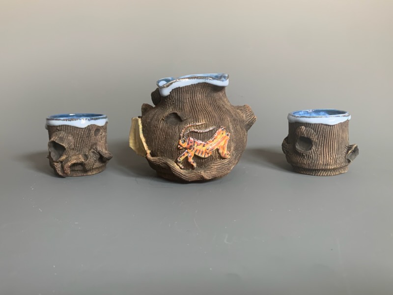 Three small ceramic containers with blue and white lids, one larger container with a dragon design, all on a gray surface.