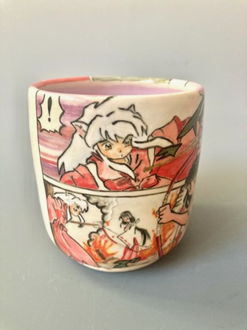 Ceramic mug with anime-style characters, featuring a girl with white hair and a red outfit, in a dynamic scene.