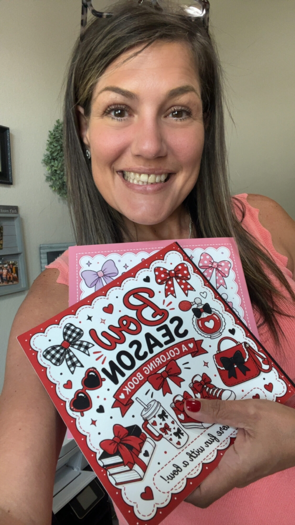 Smiling woman holding a Valentine's Day card with red, black, and white decorations, including bows, hearts, and a dog silhouette.