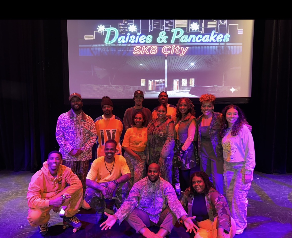 Group of ten people on stage in front of a screen with text 'Daisies & Pancakes SAS City'.