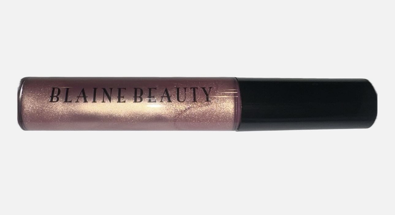 Lip gloss tube with black cap and metallic pink body, labeled 'BLAINE BEAUTY'.