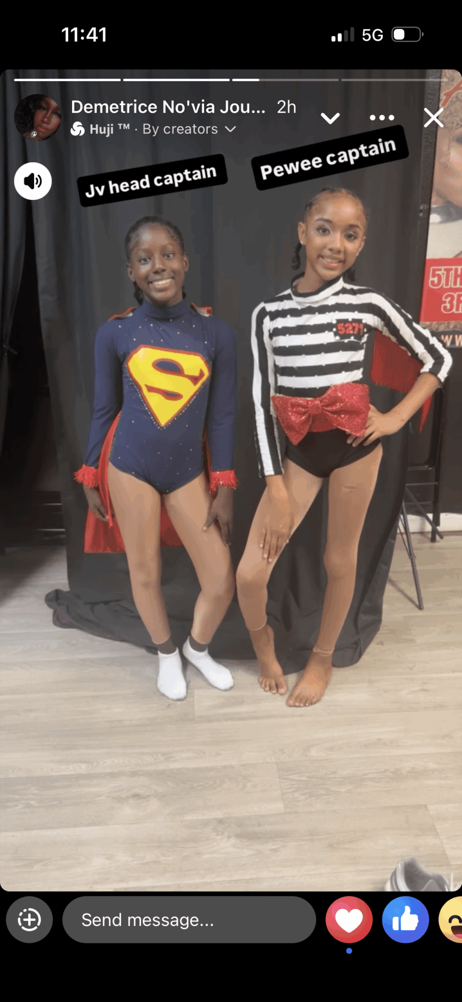 Two children in costumes, one as Superman and the other as a pirate, standing indoors with a black background.