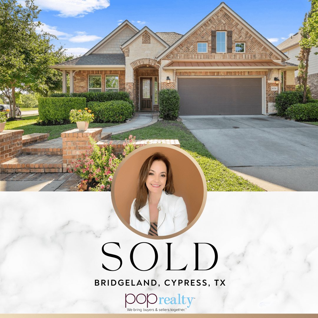 Front view of a house with a garage, trees, and a lawn, indicating a sold property in Cypress, Texas.