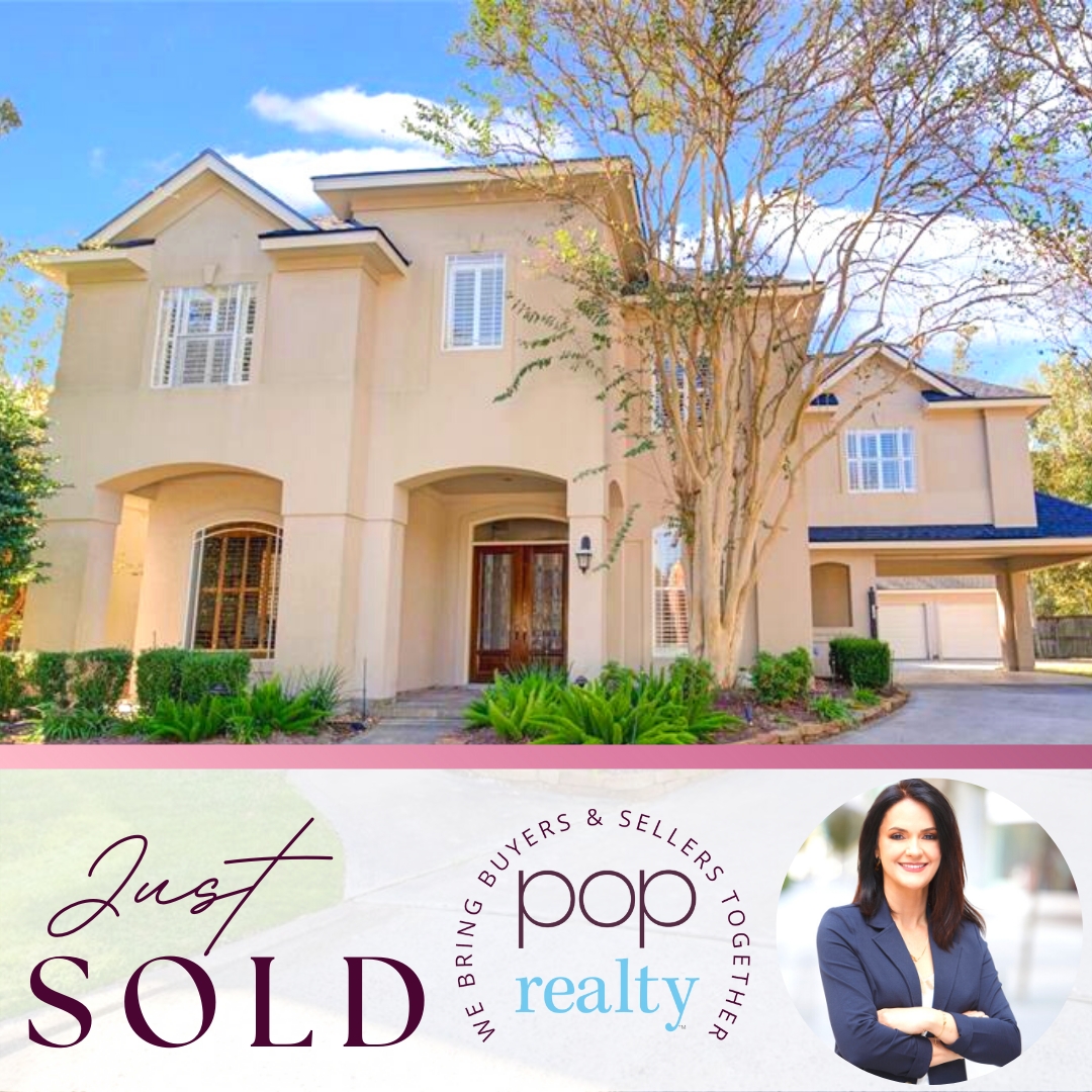 A sold sign with a woman in a blazer, house, and trees in the background, promoting real estate services.