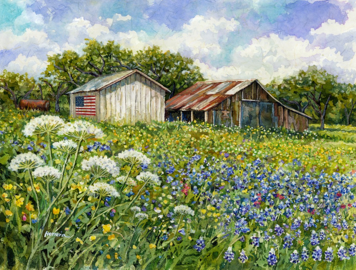 A rural scene with two weathered barns, a field of wildflowers, trees, and a partly cloudy sky.