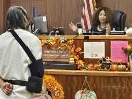 Judge speaking to a person in a courtroom with autumn decorations on the desk.