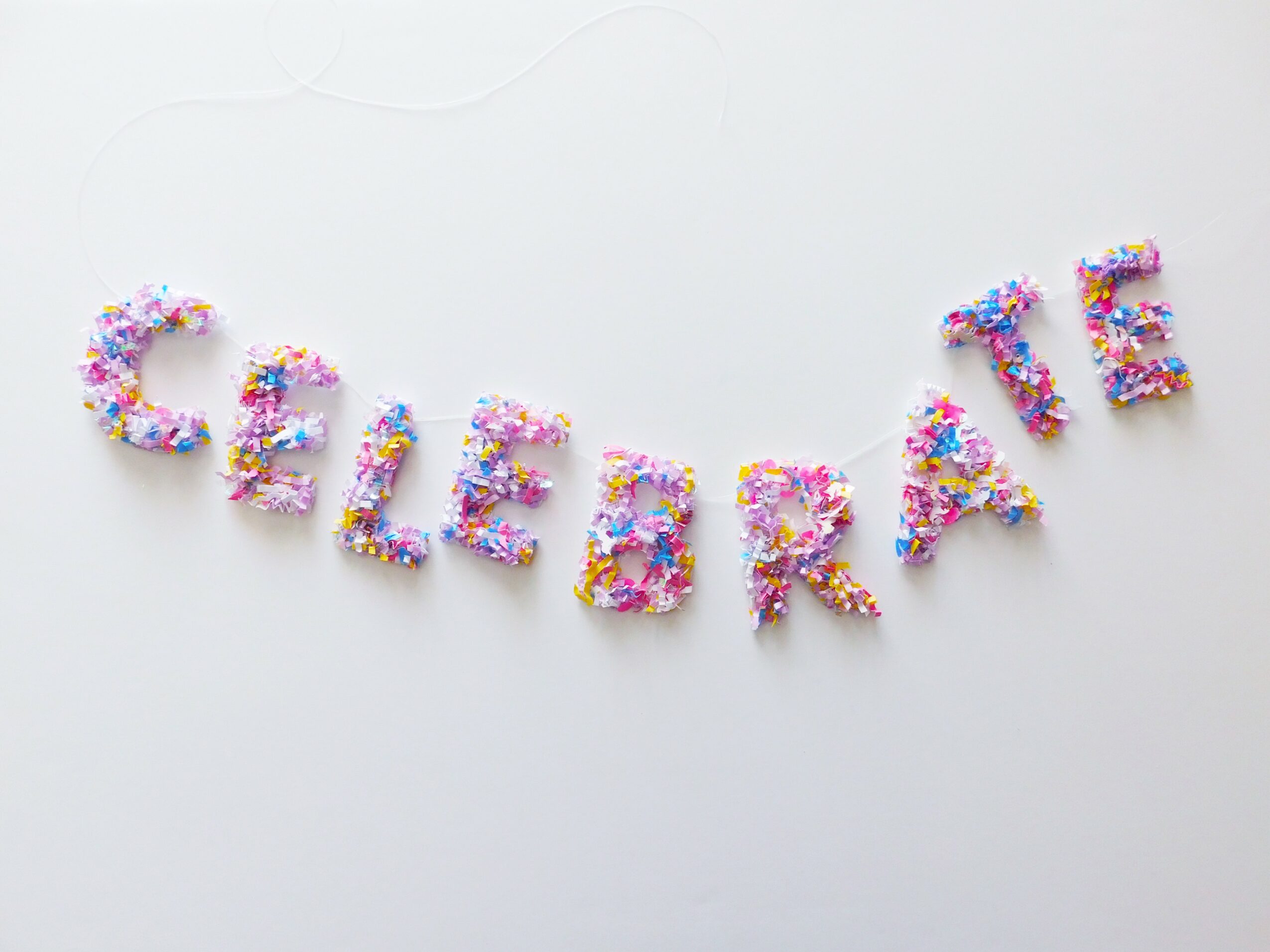 Colorful letters spell out 'CELEBRATE' on a white background.