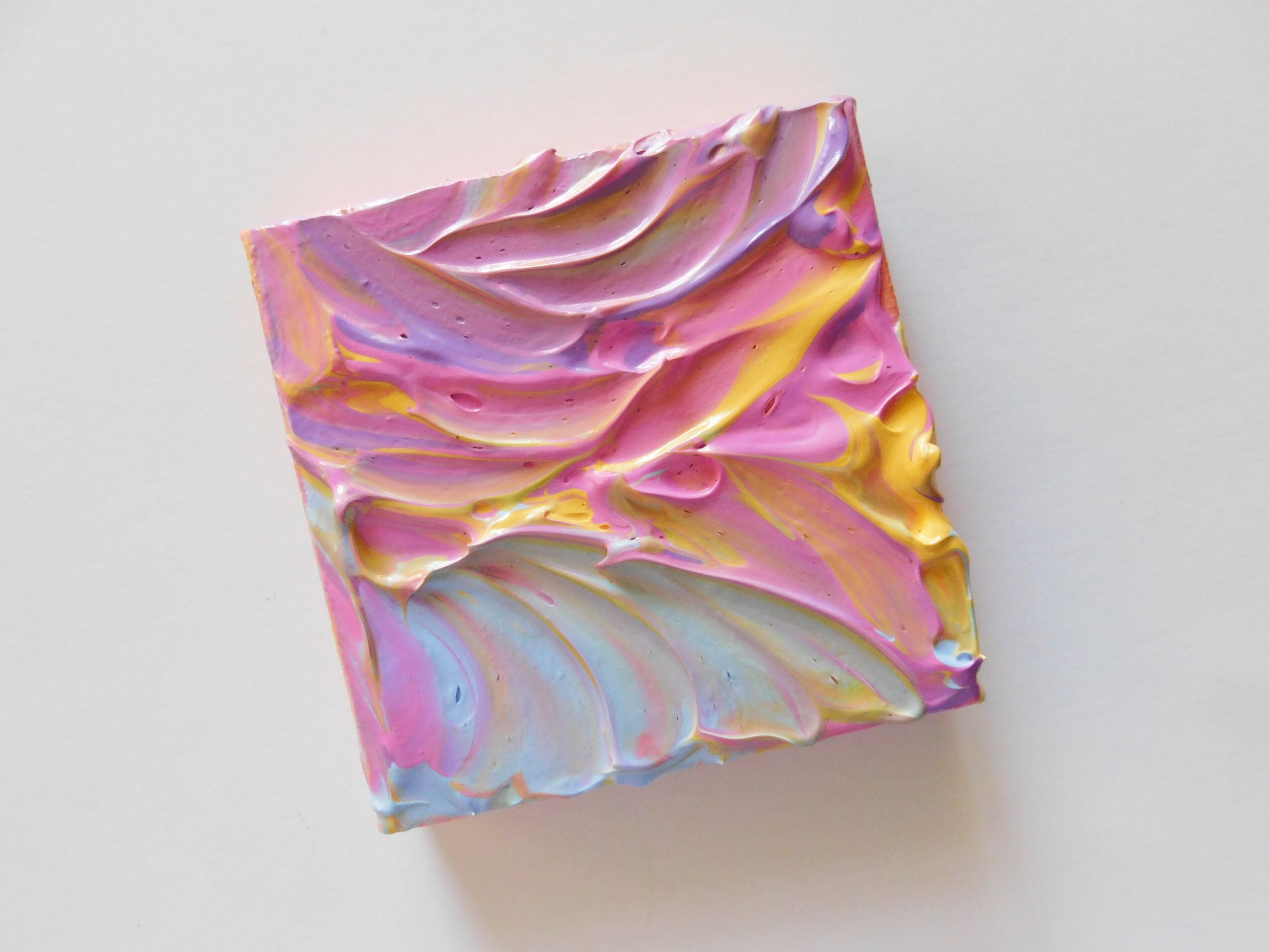 Colorful abstract textured painting with pink, yellow, and blue swirls on a white background.