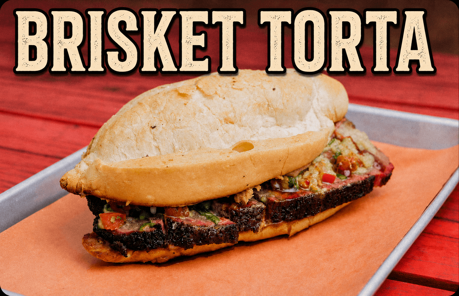 Sandwich with grilled meat, vegetables, and bread on a tray, with text 'BRISKET TORTA' above.