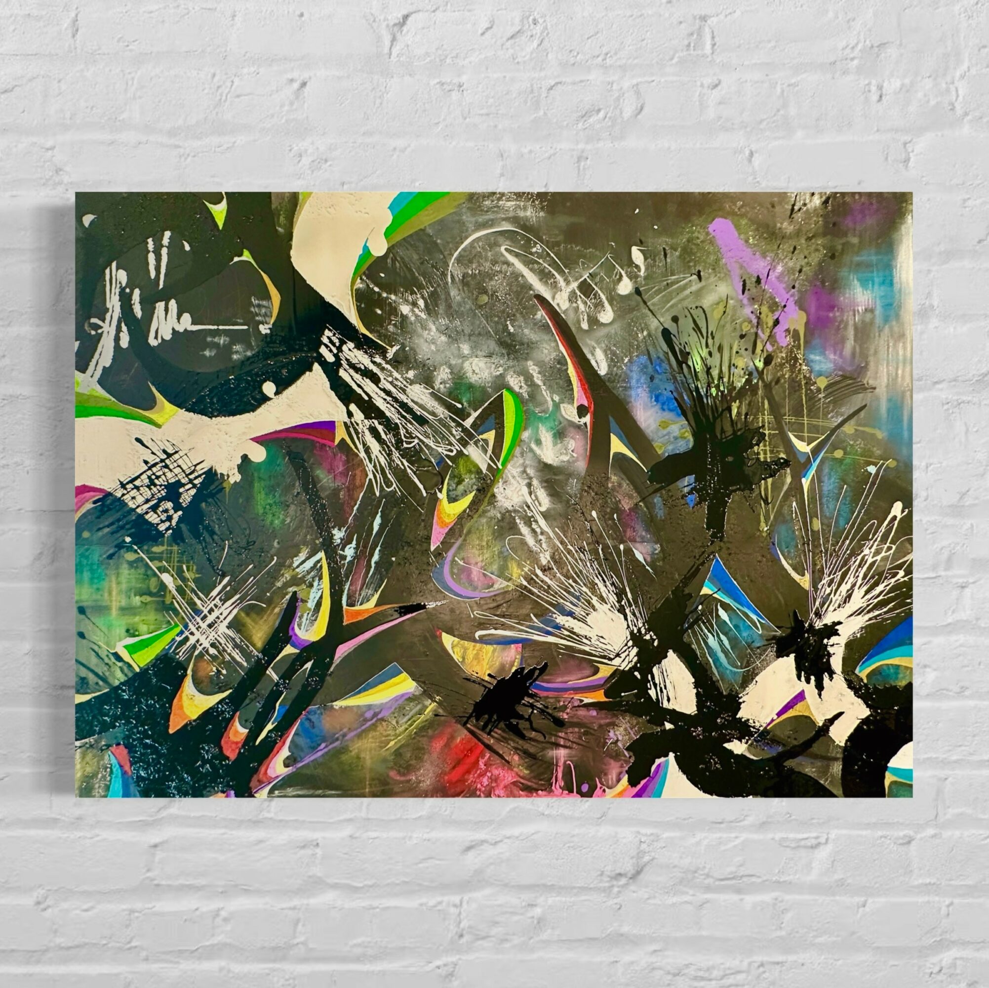 Abstract painting with colorful splashes, black shapes, and dynamic brushstrokes on a white brick wall background.