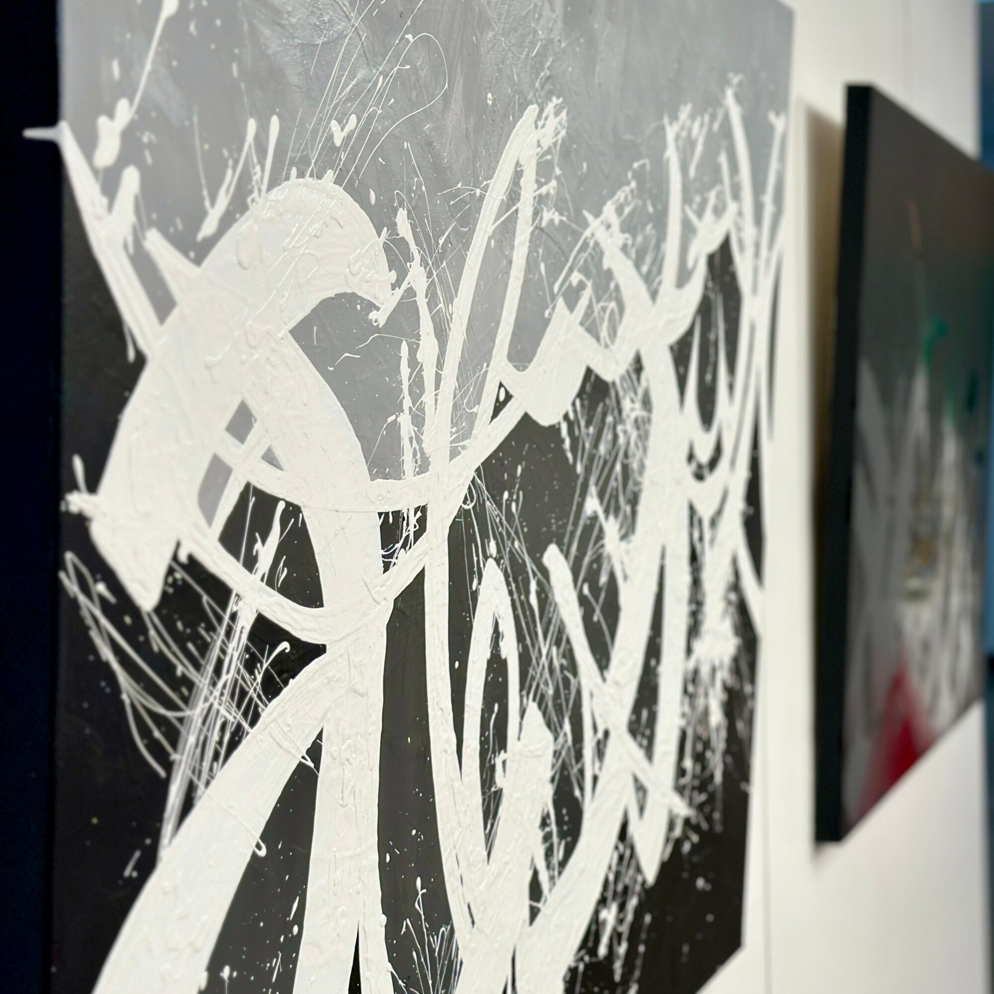 Abstract black and white painting with bold, splattered strokes and dynamic lines on canvas.