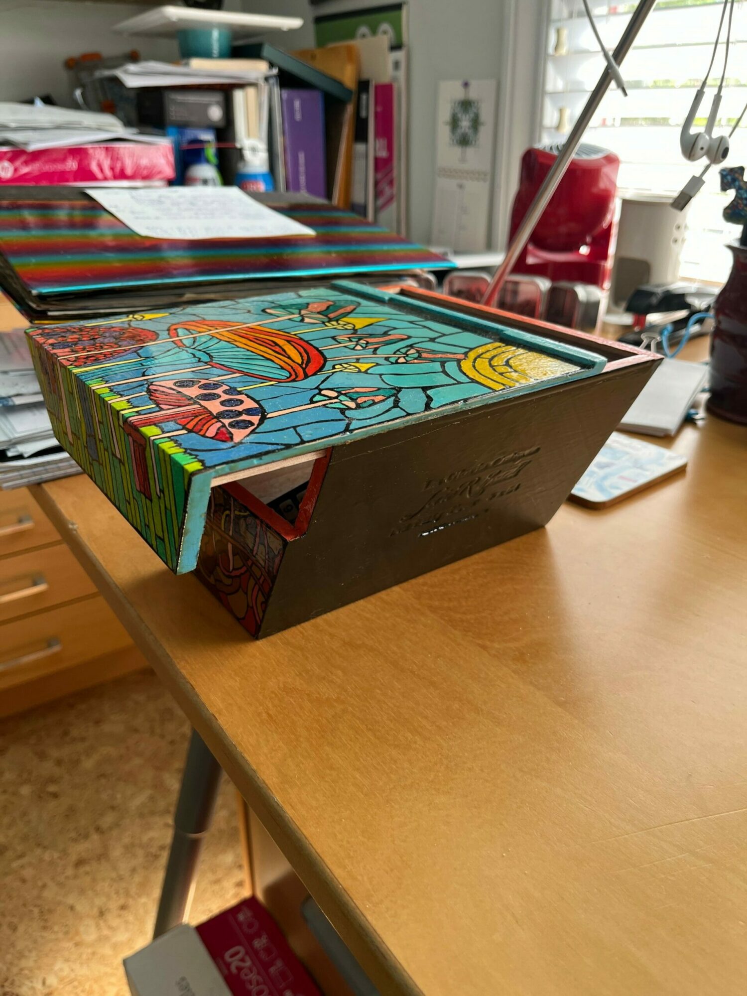 Colorful children's book with a rainbow and smiling sun on a wooden table.