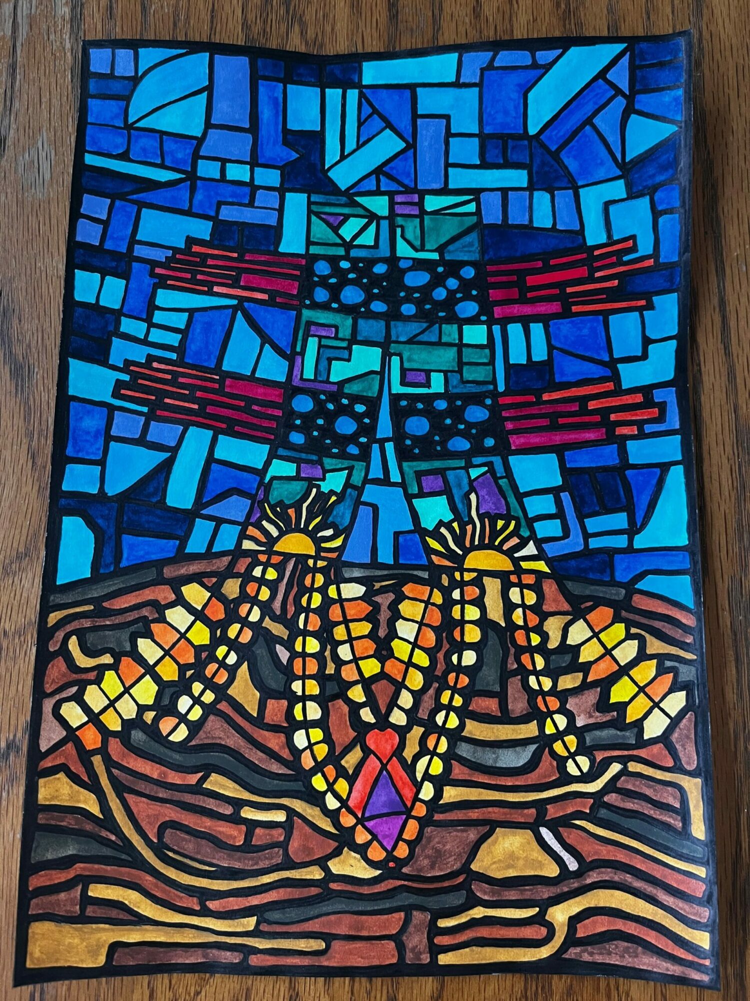 Stained glass window with blue geometric patterns on the left and yellow, orange, and brown abstract shapes on the right.
