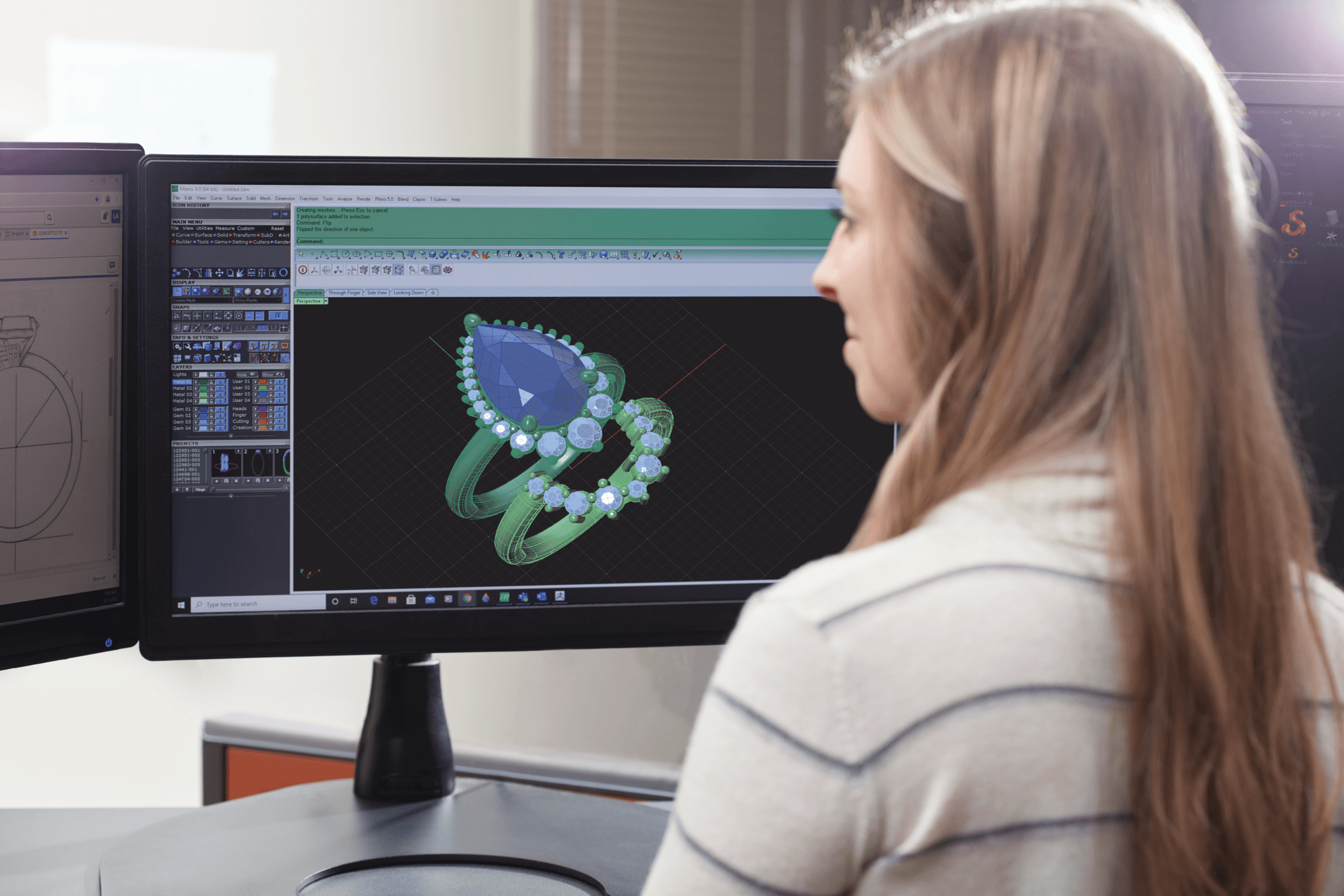 Woman with long hair working on a computer with a design of a butterfly on the screen.