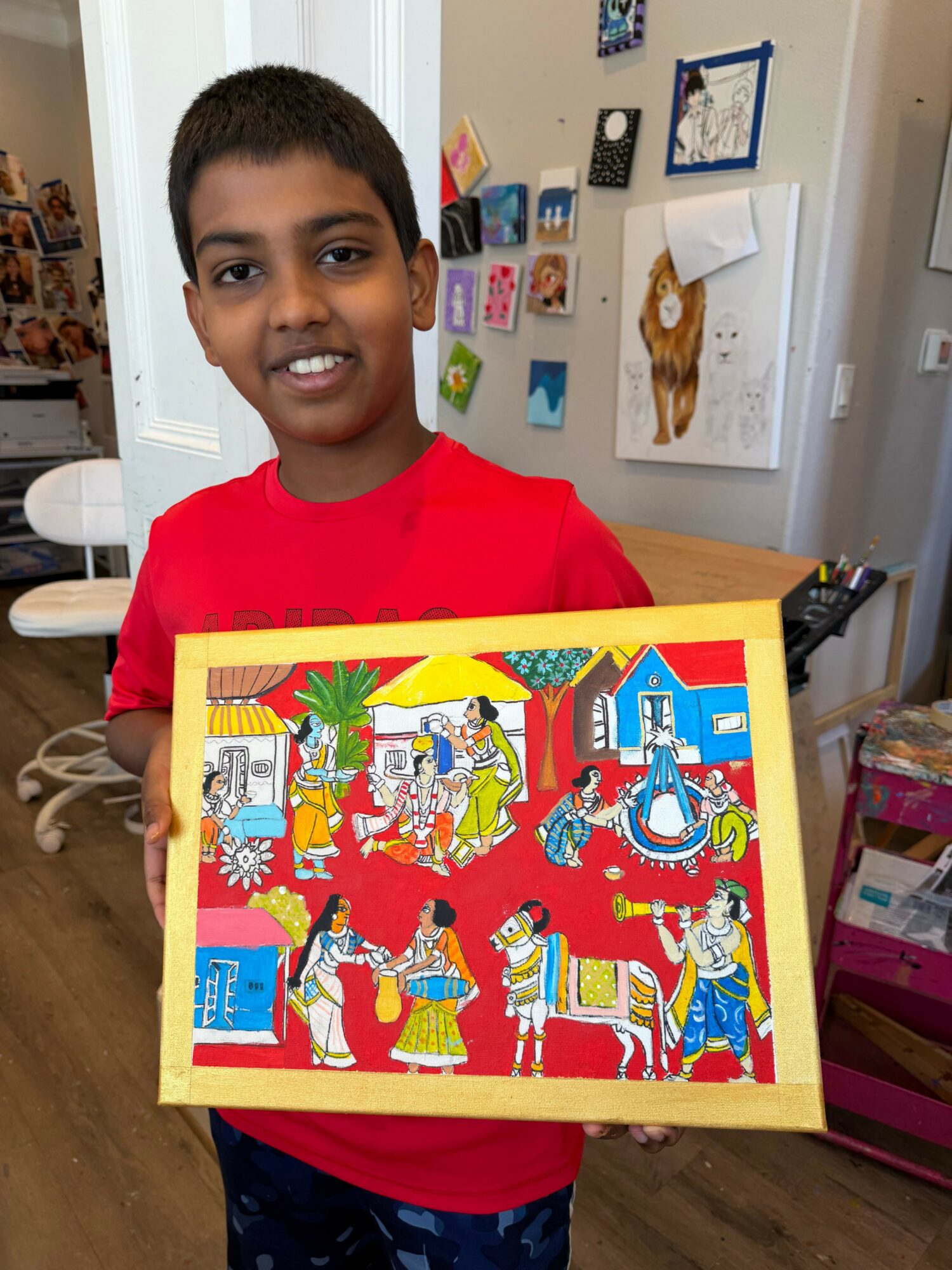 Child holding a colorful puzzle with a festive scene, smiling in a room with wall decorations and a door.