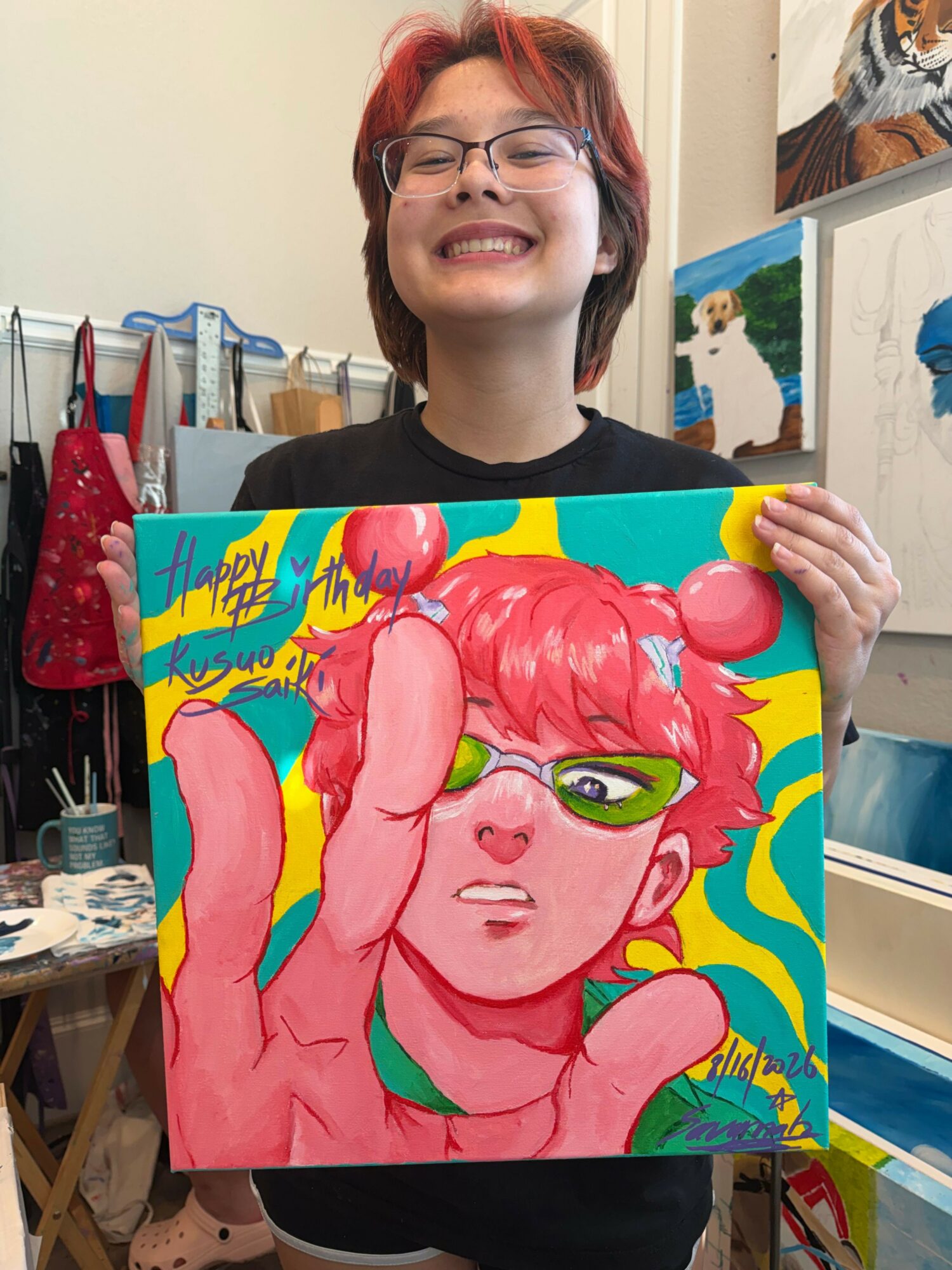 Person holding colorful, stylized portrait of a pink-haired character with green eyes, surrounded by vibrant background elements.