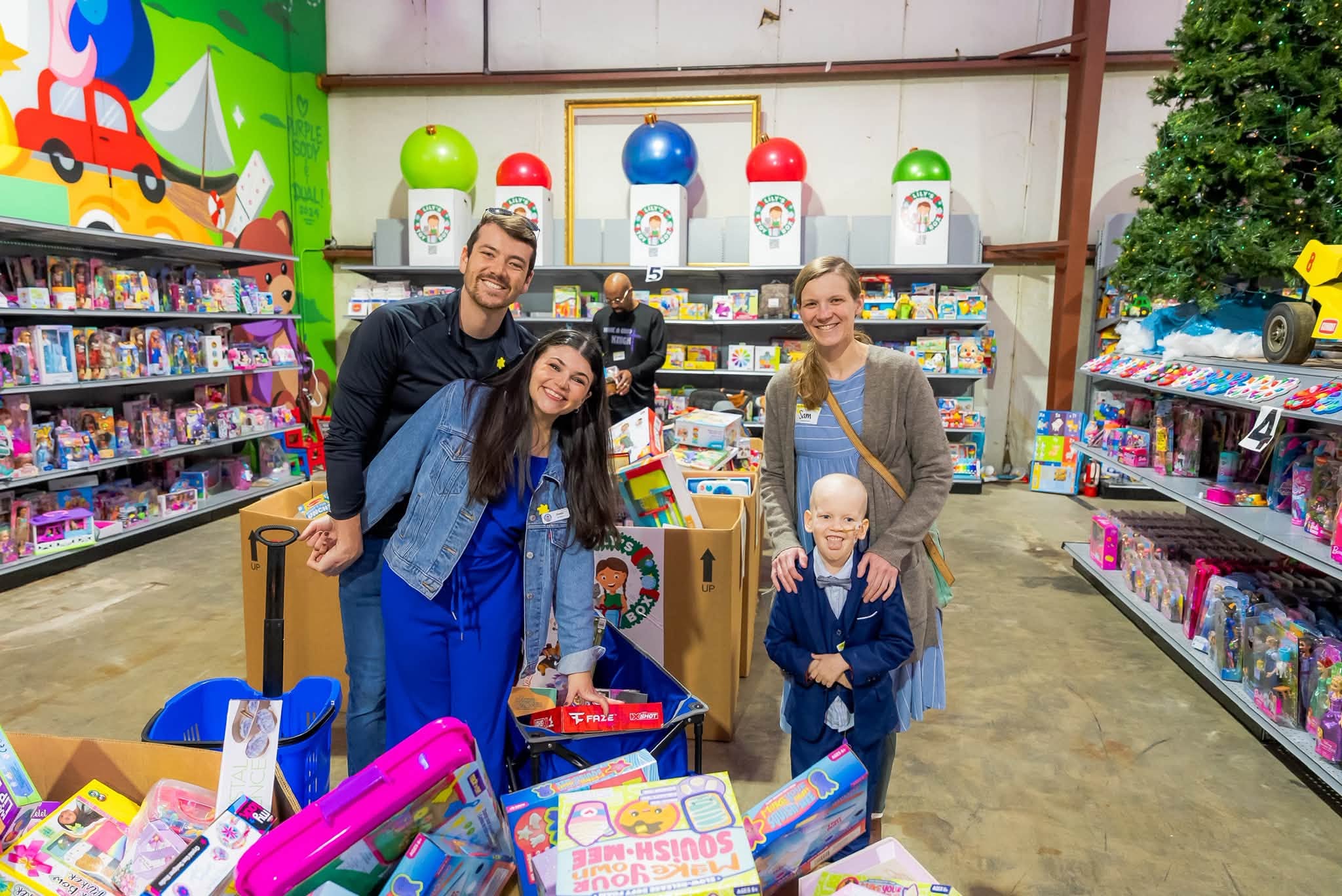 Group of four people shopping for toys in a store, smiling, with shelves of toys and games around them.