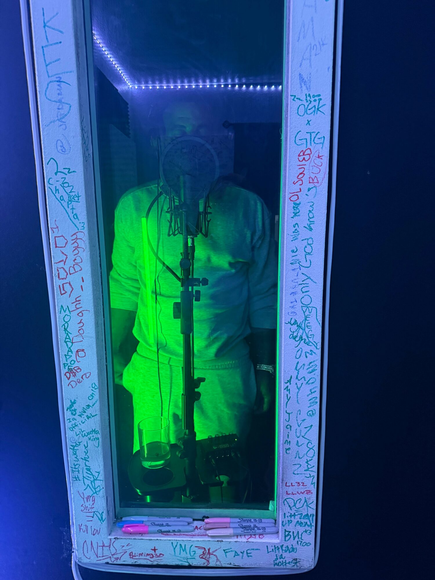 Smartphone displaying northern lights, surrounded by handwritten notes and drawings, under blue lighting.