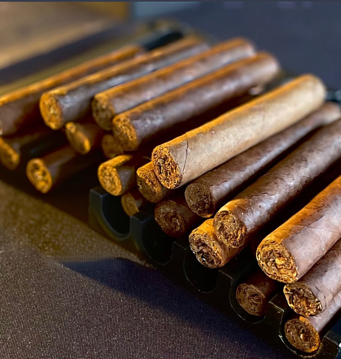 Cinnamon sticks arranged on a black surface, some broken, with a blurred background.