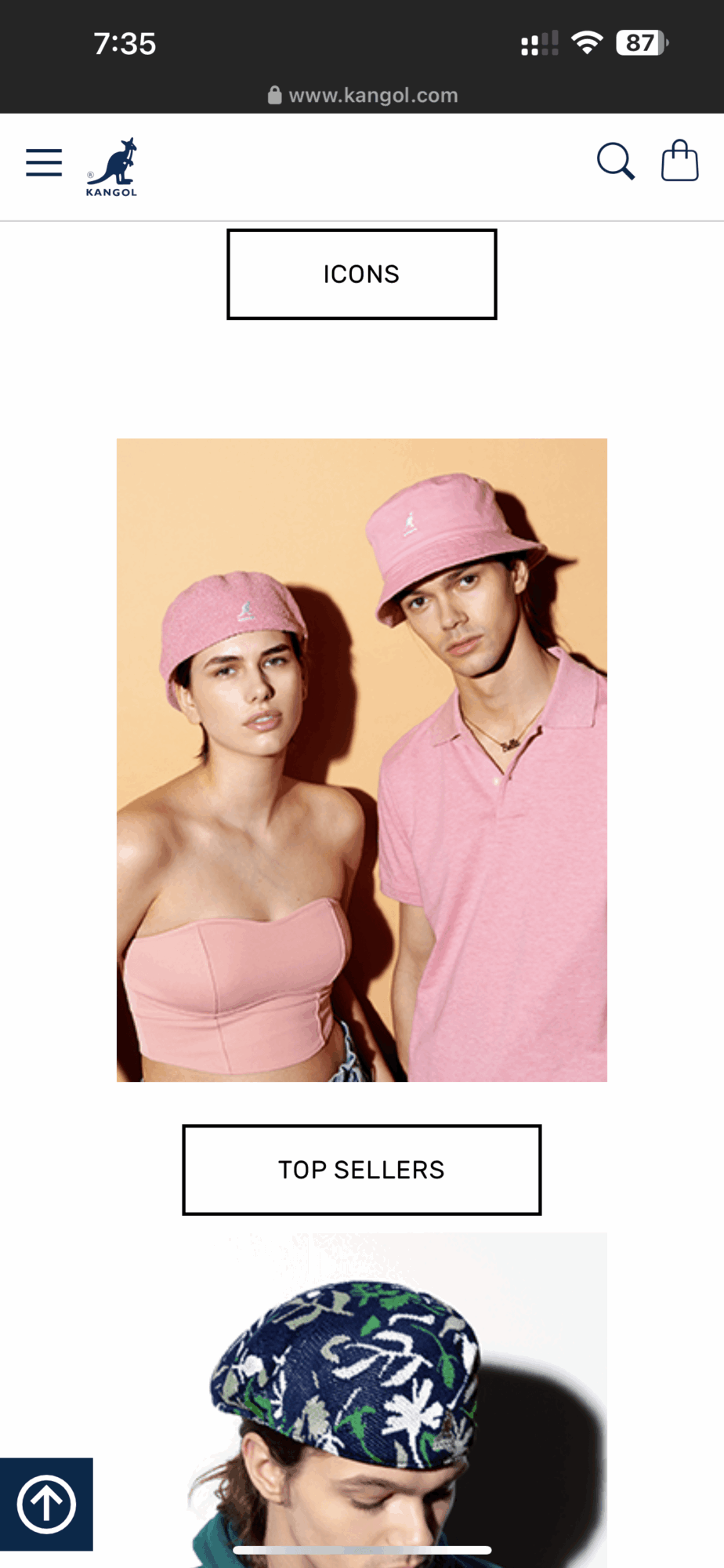 Two young women wearing pink hats and tops, standing side by side against a beige background.