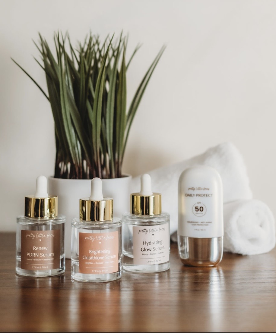 Skincare products and towels on a wooden surface with a plant in the background.