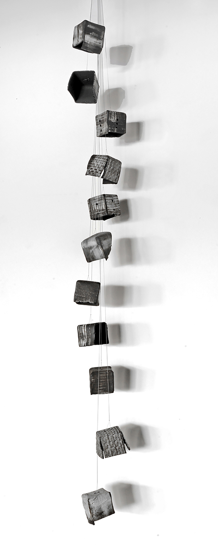 Stack of small cubes falling, with shadows on a light background.