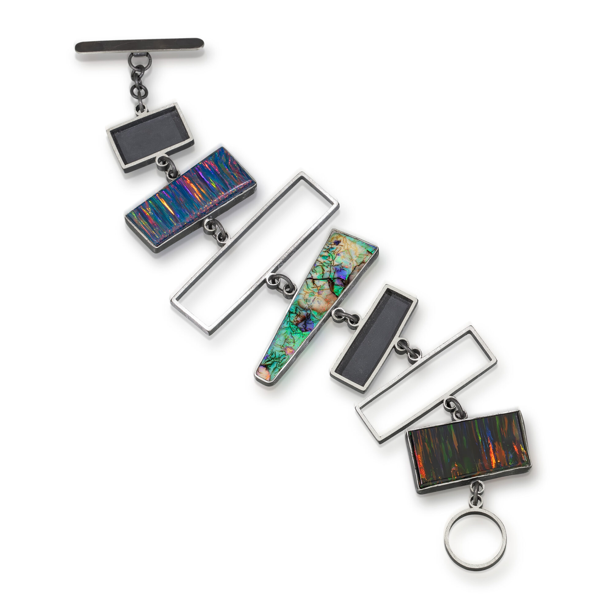 A decorative bracelet with rectangular and circular elements, some with colorful patterns, arranged diagonally on a white background.