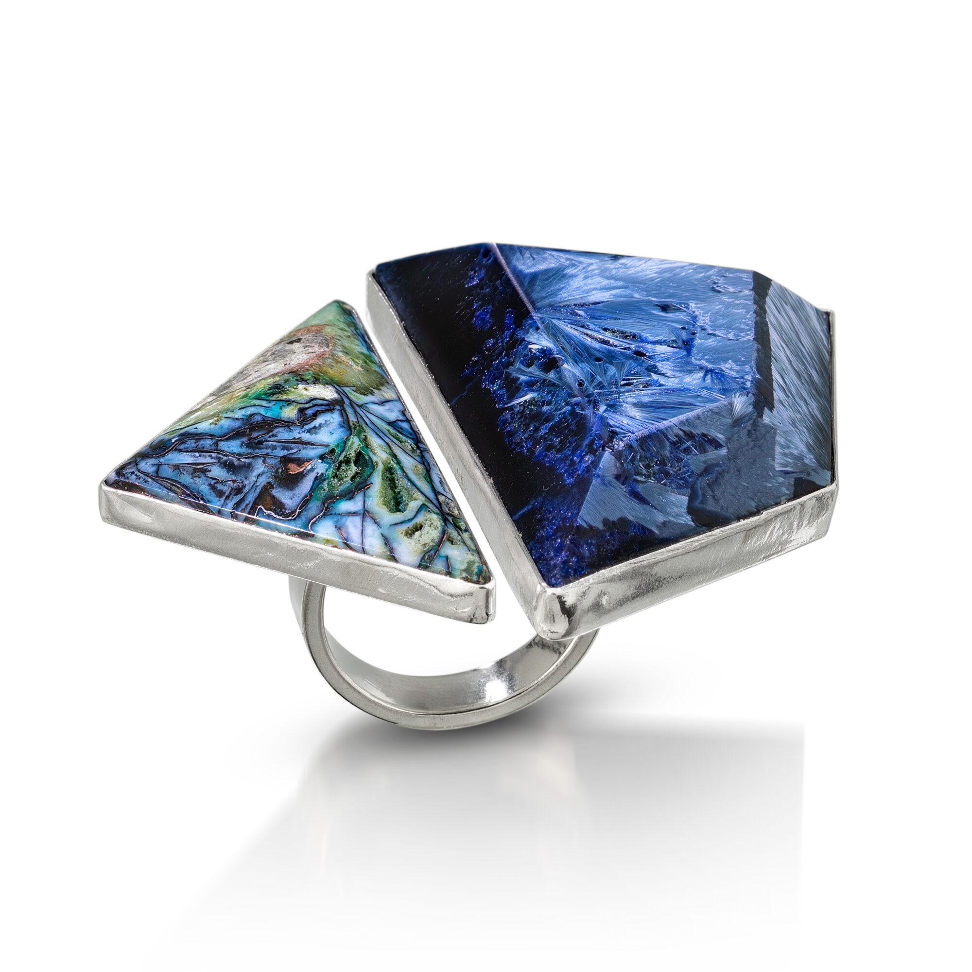 Ring with two large, irregularly shaped stones, one blue and one multicolored, set in a silver band.