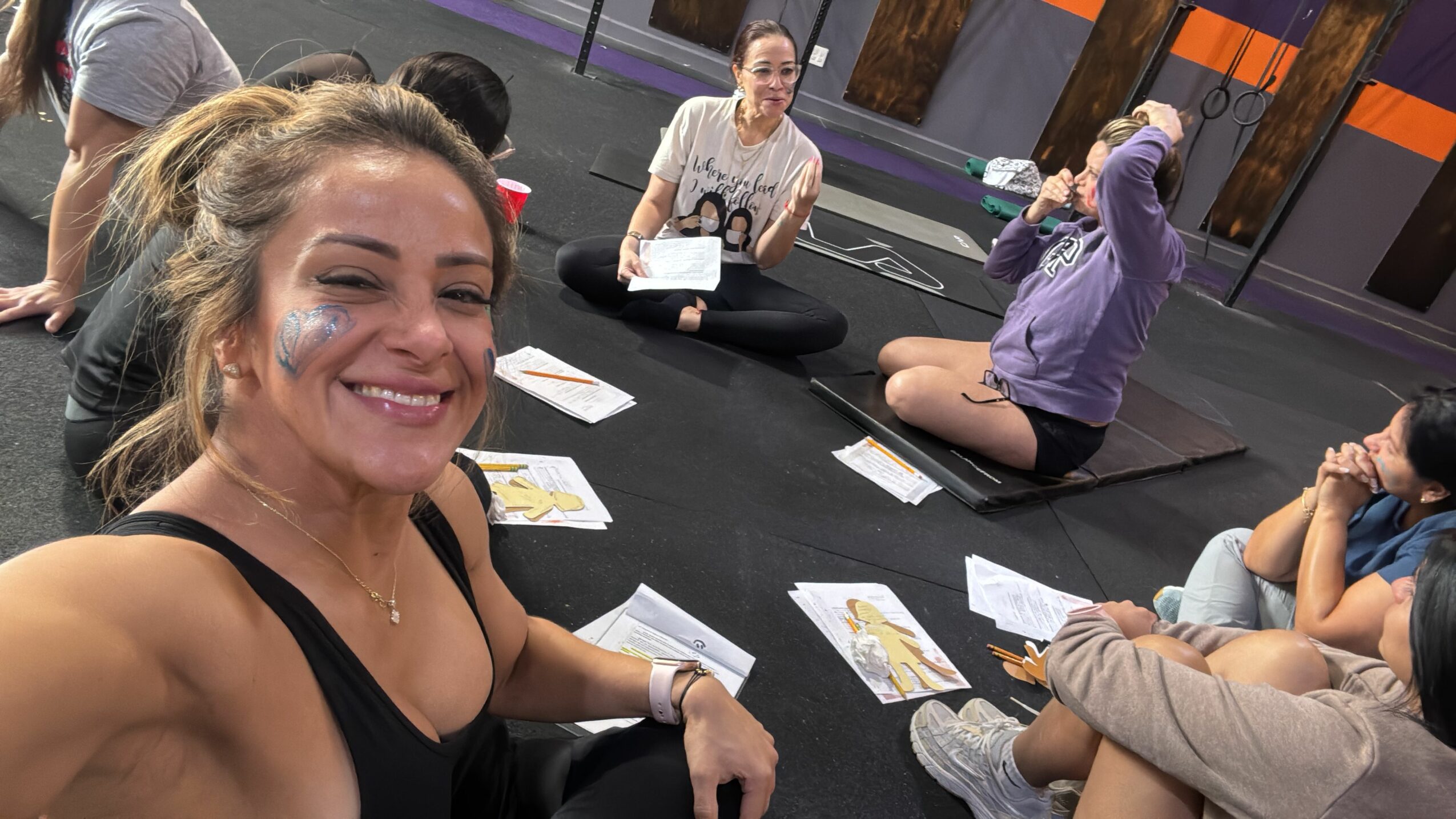 People sitting at a table with papers, and a woman smiling at the camera, upside down.