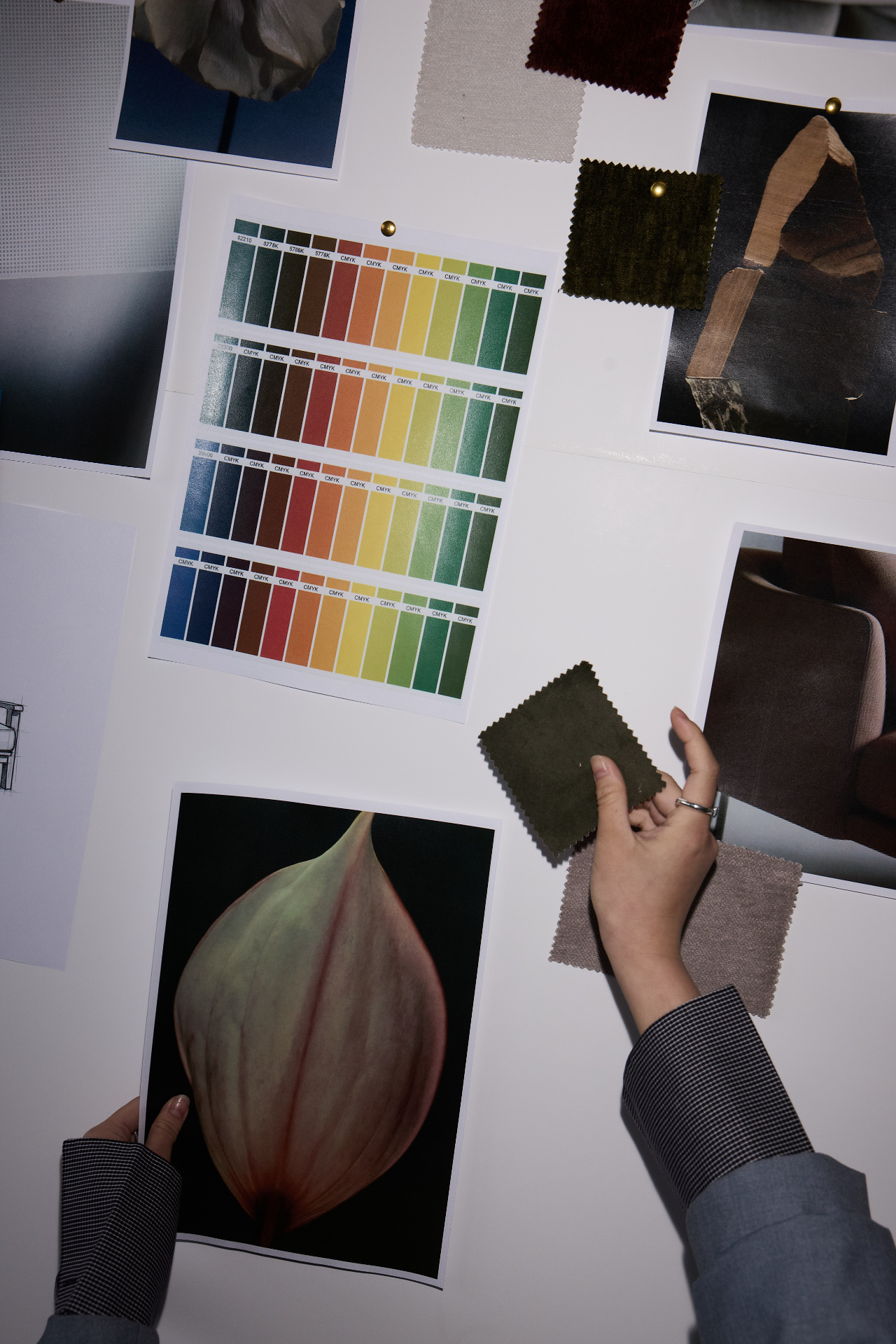 Person holding a small dark fabric swatch, with a large flower image and color palette on a white background.