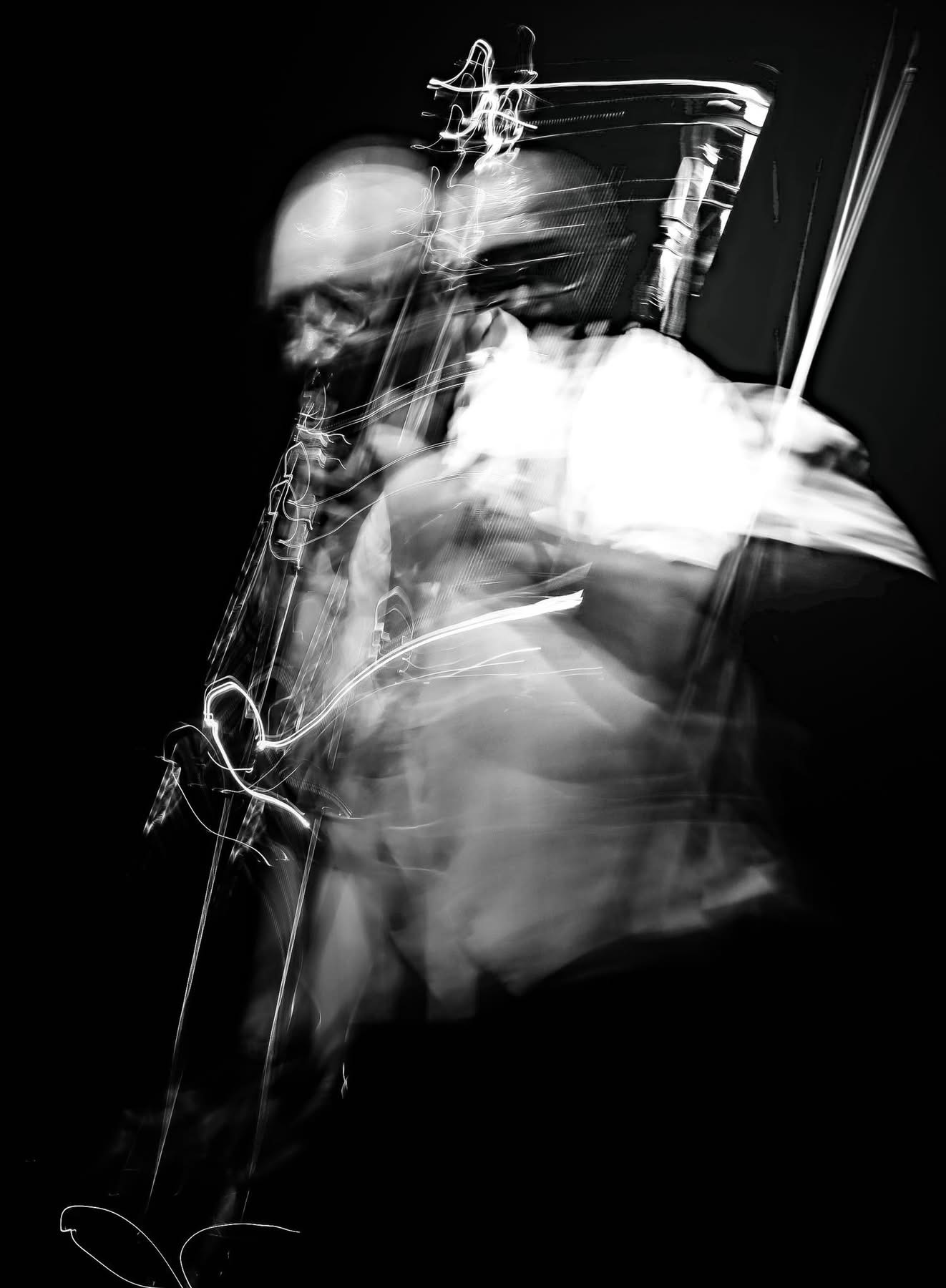 Abstract black and white image of a person playing a saxophone with motion blur effects.