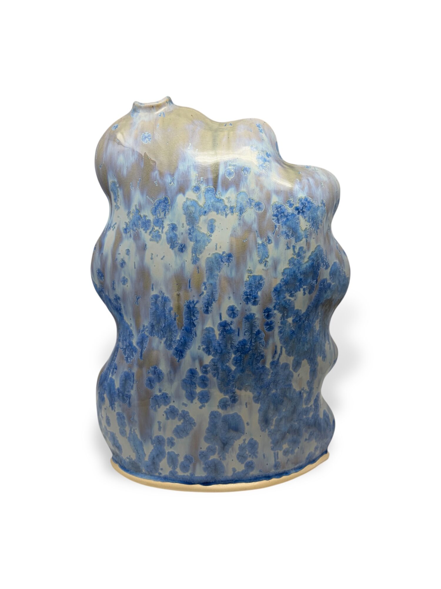 Ceramic vase with a wavy shape, glazed in blue, beige, and white colors, with a textured surface.