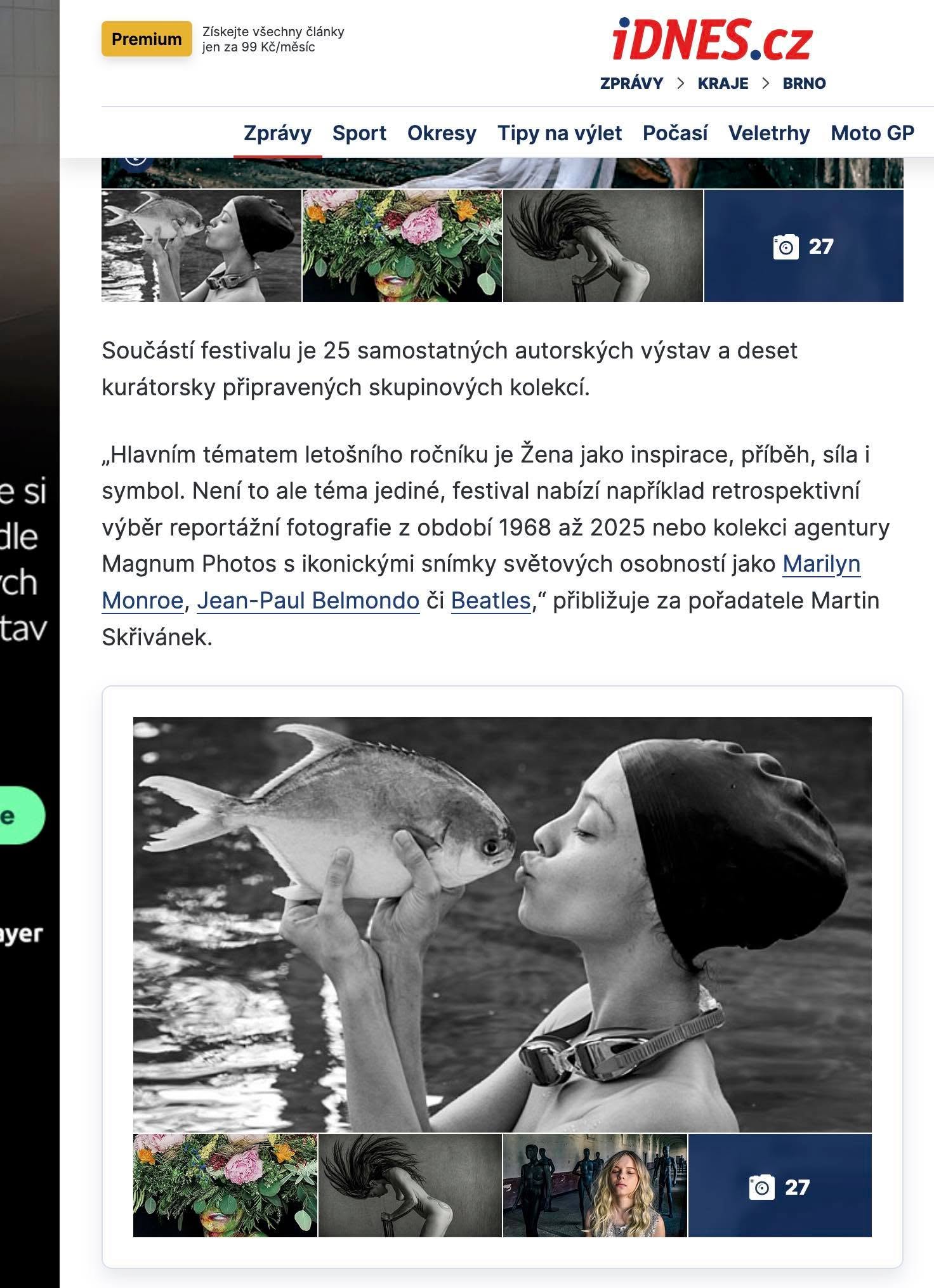 Black and white photo of a woman holding a fish near her face, with water in the background.