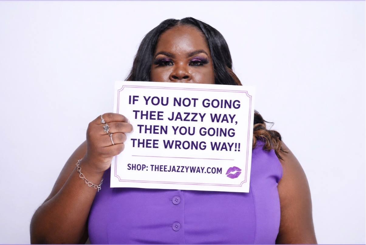 Woman holding a sign with a message about going the right way, wearing a purple top, against a white background.