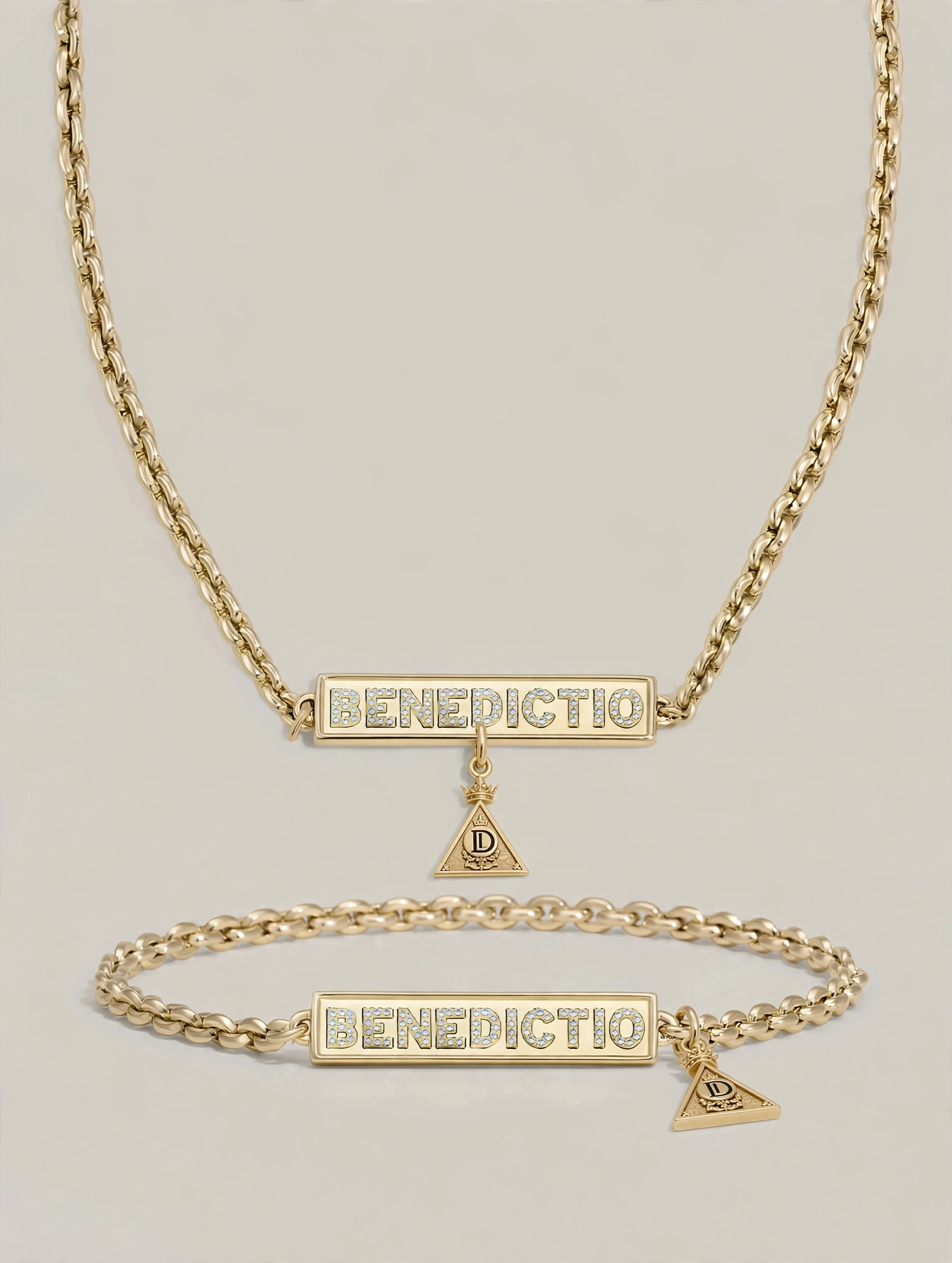 Gold necklace and bracelet with rectangular pendants engraved with 'BENDICTIO' and small triangular charms.