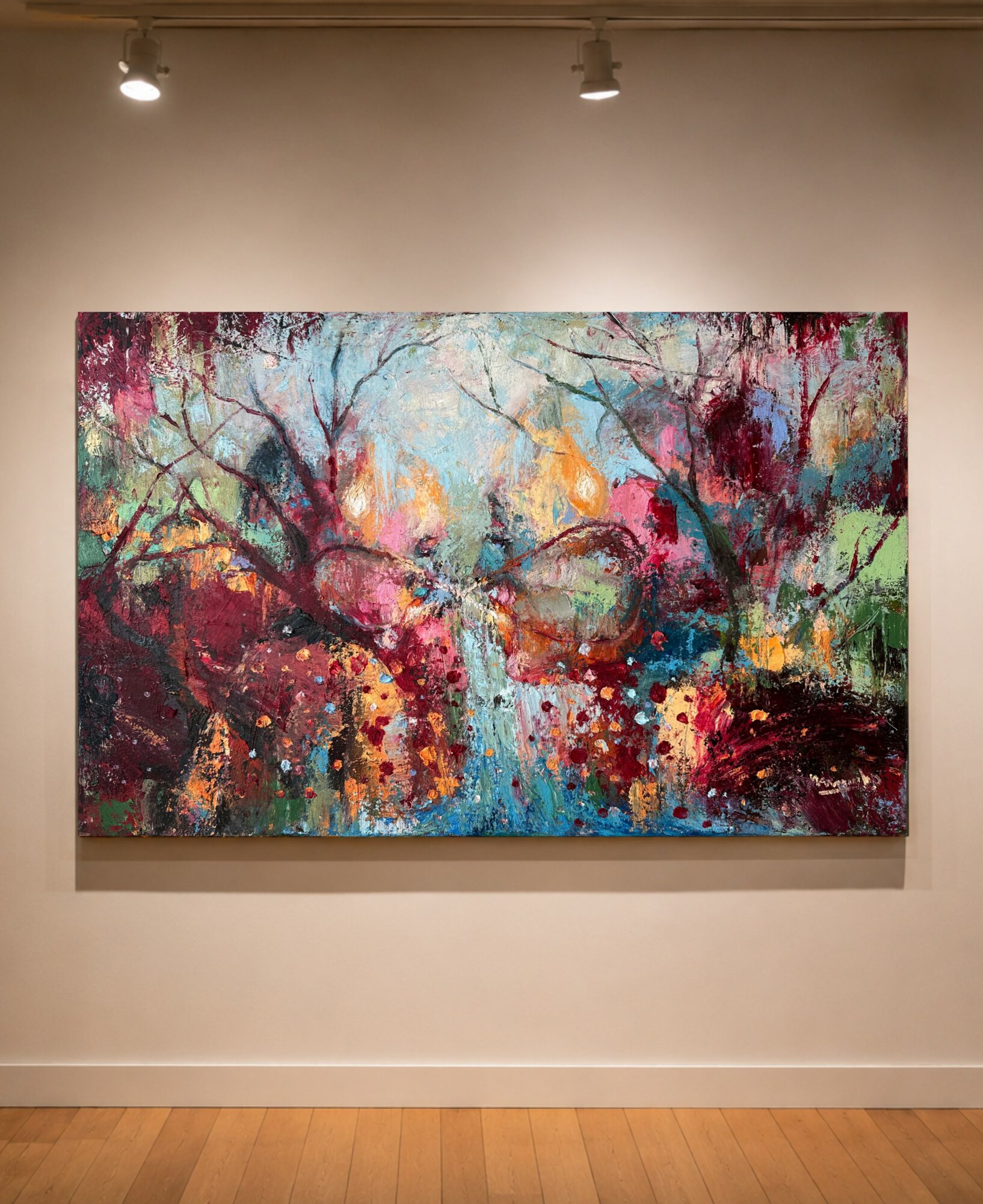 Colorful abstract painting of trees with vibrant splashes of pink, blue, yellow, and green on a gallery wall.