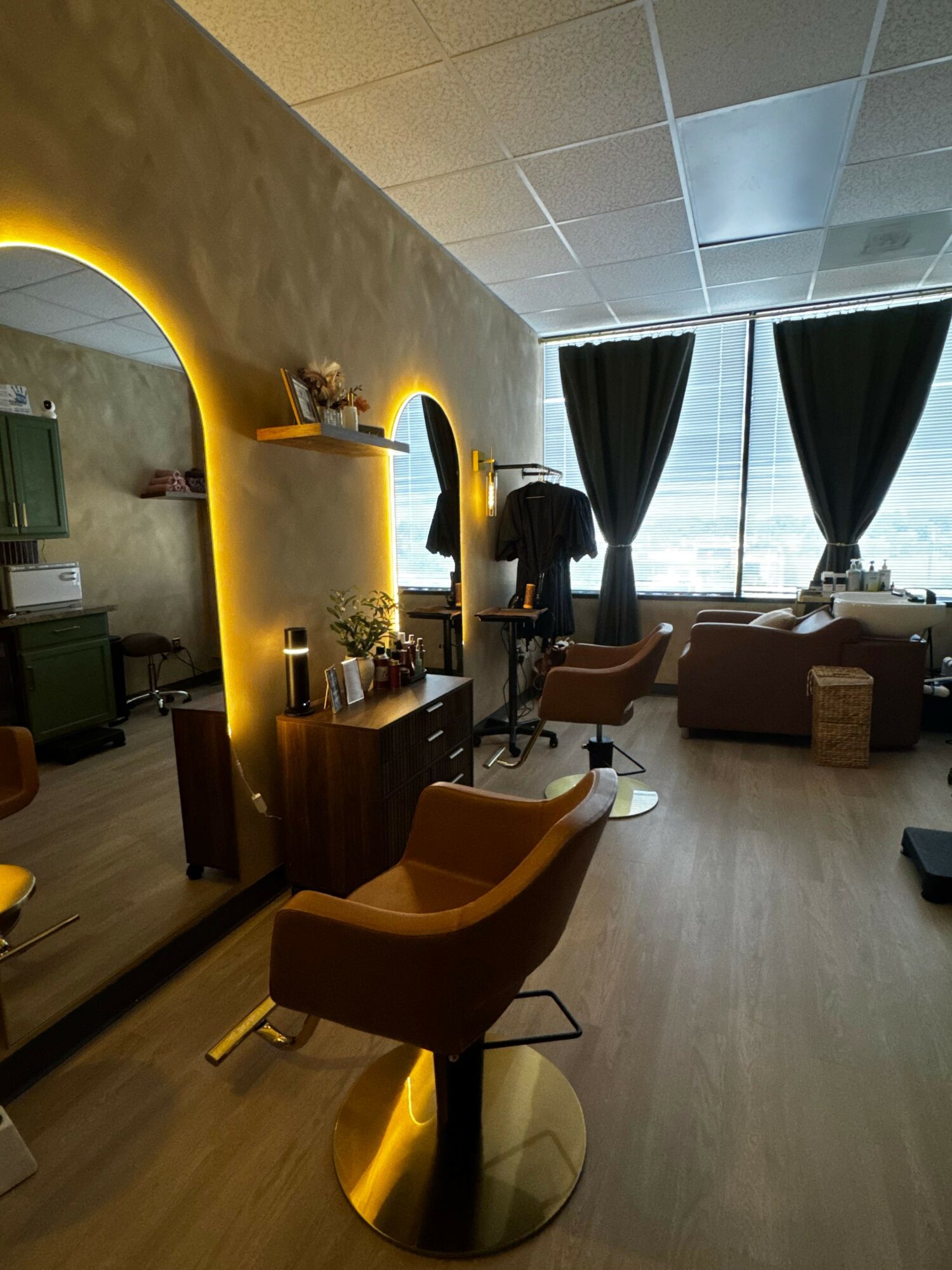 Living room with a curved wall, a window with curtains, and a wooden floor. Furniture includes a table and chairs.