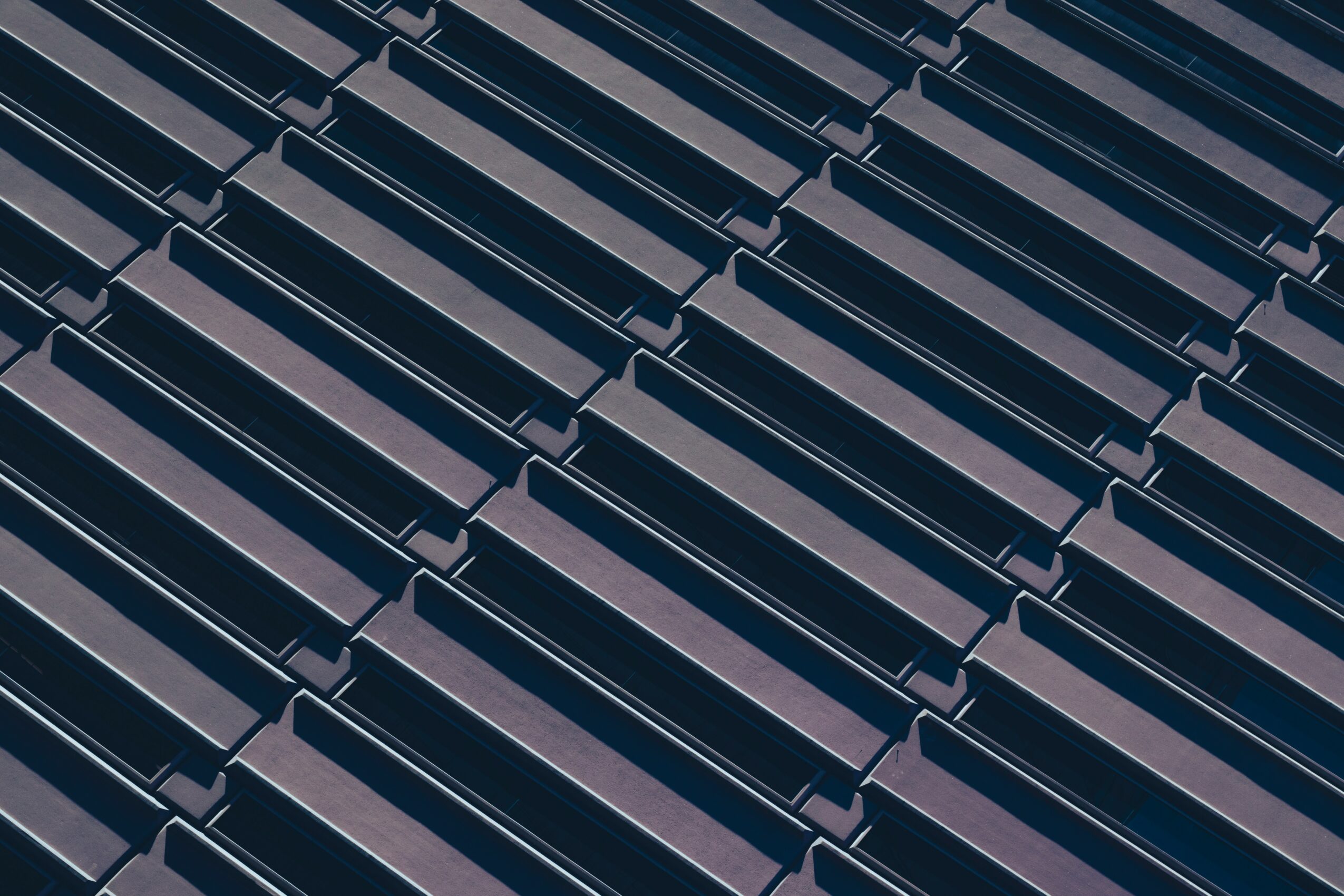 Close-up of dark-colored roof tiles arranged in a repeating pattern.