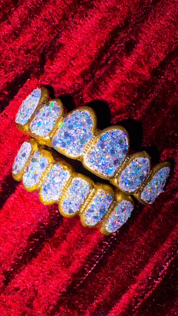Jewelry piece with blue and white stones set in gold, displayed on red fabric background.