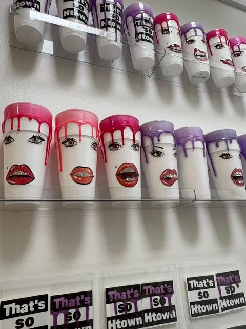 Rows of colorful nail polish bottles on a white shelf, with some stickers or labels nearby.