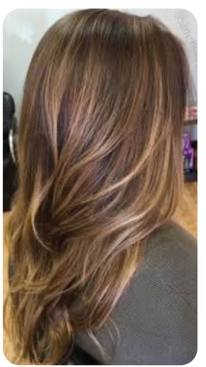 Side view of a person with long, wavy, light brown hair with subtle highlights.