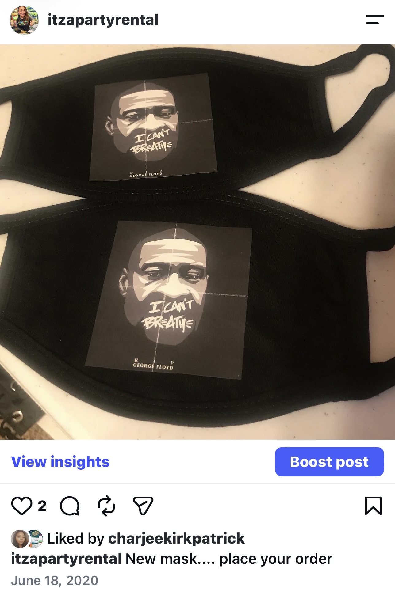 Two black face masks with a printed image of a person's face and text, placed on a surface.