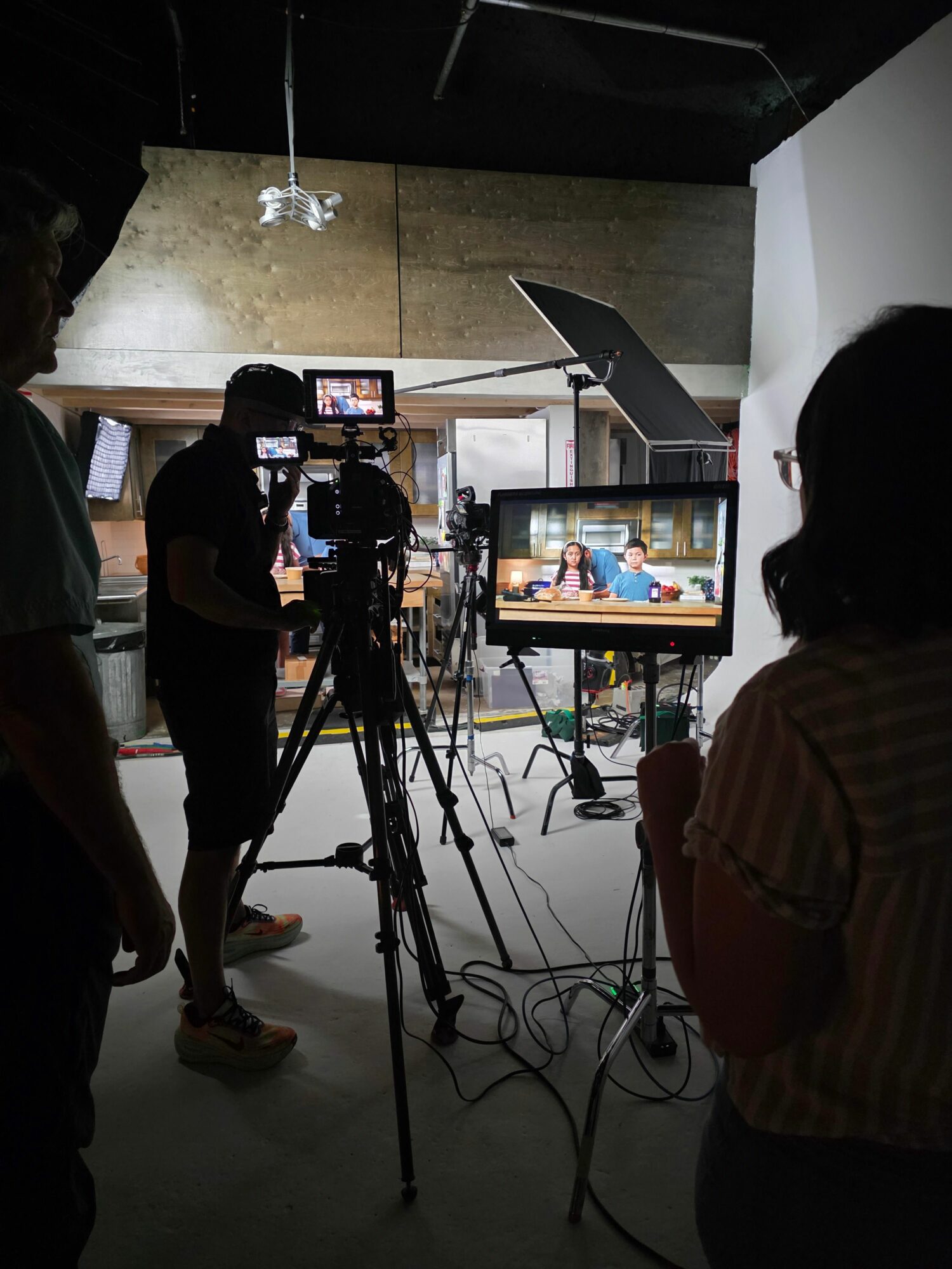 People in a studio with cameras and monitors, filming or recording a scene or interview.