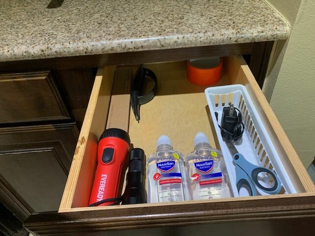 Inside a small refrigerator with bottles, a red flashlight, and a black object, viewed from above.