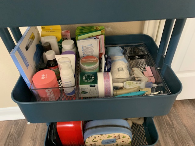 Open blue first aid kit with medical supplies inside, on a white surface.