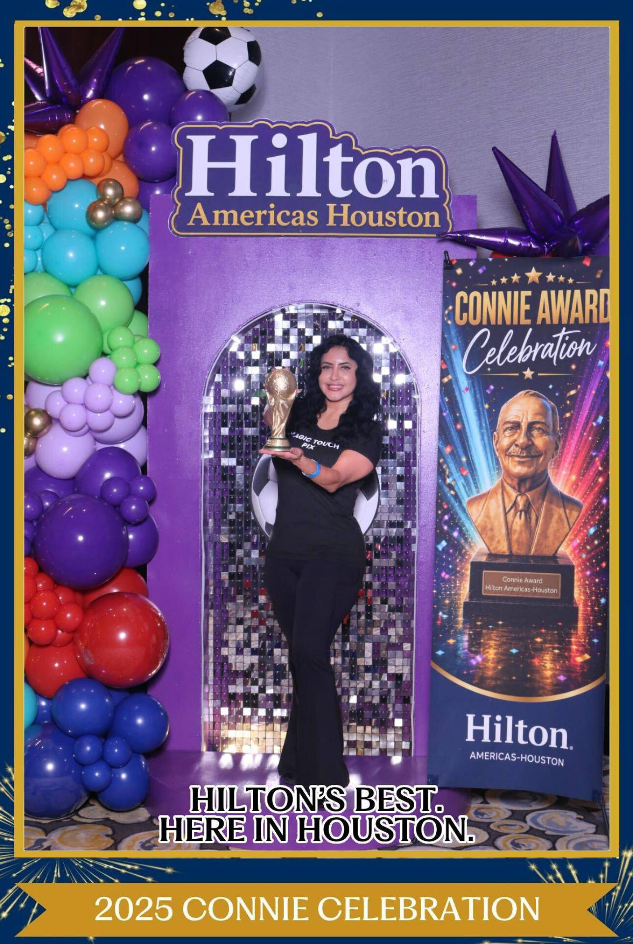 Woman standing in front of a decorated backdrop with balloons, a Hilton sign, and a poster for the 2025 Connie Celebration.