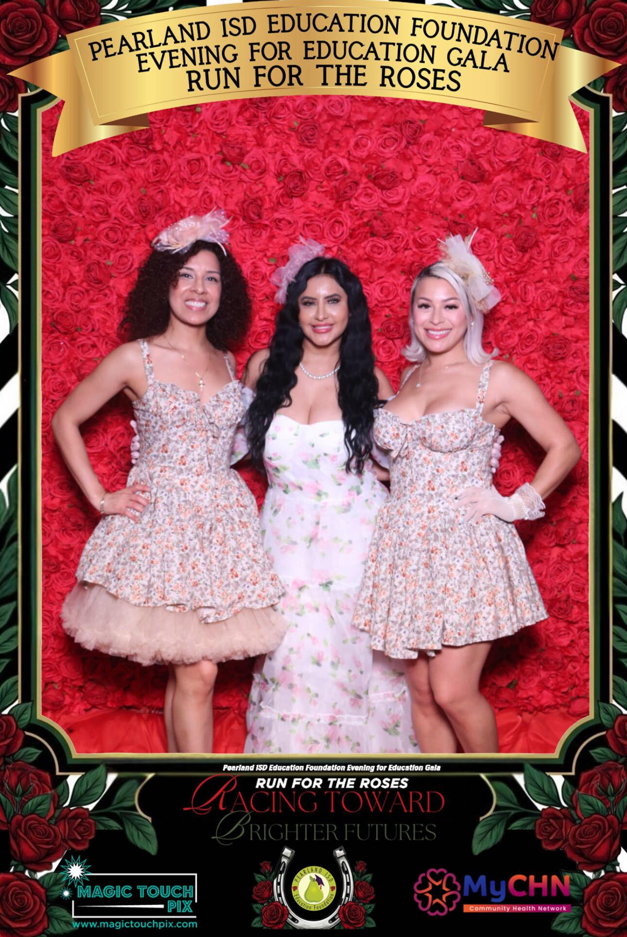Three women in floral dresses standing in front of a red floral backdrop at an event, smiling and posing for the photo.