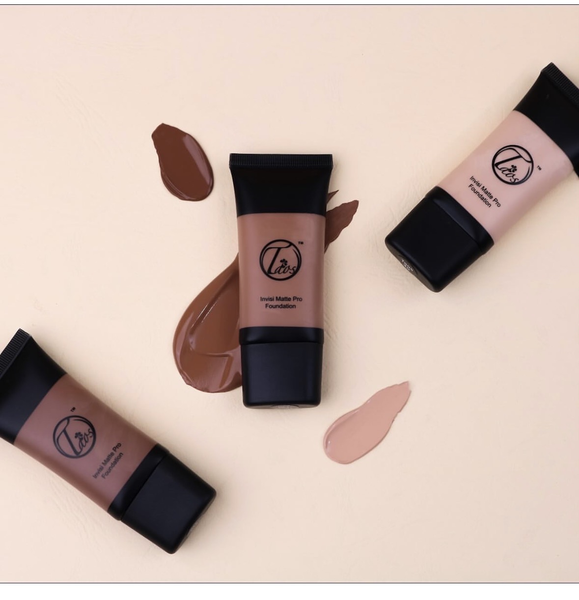 Three tubes of foundation with swatches on a light background, arranged diagonally.
