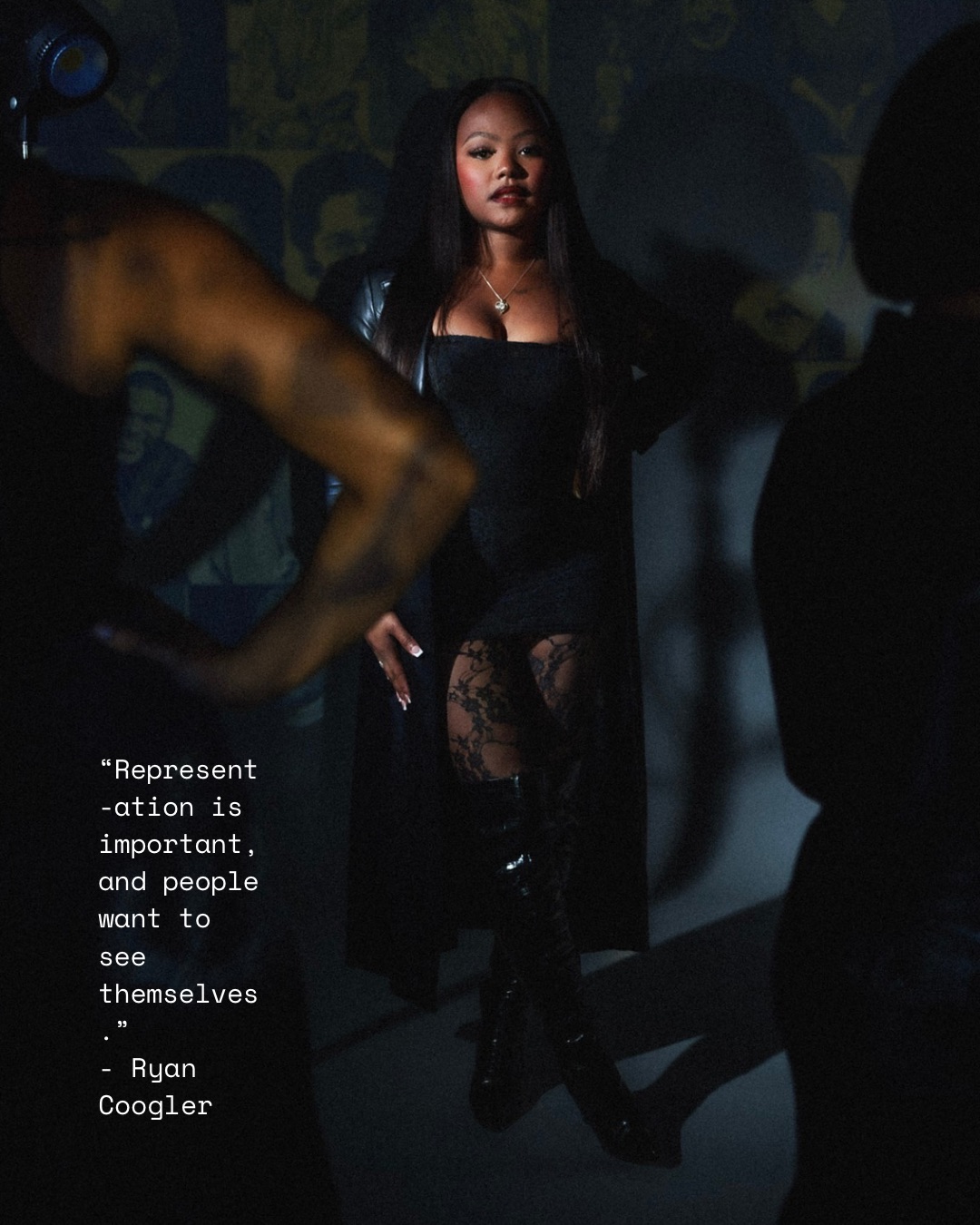 A woman with long dark hair stands in a dark setting, wearing a black outfit with lace details, surrounded by silhouettes.